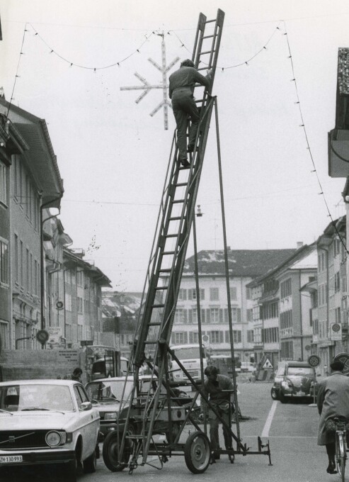 Montage der Weihnachtsbeleuchtung in der Steinberggasse, 1975.